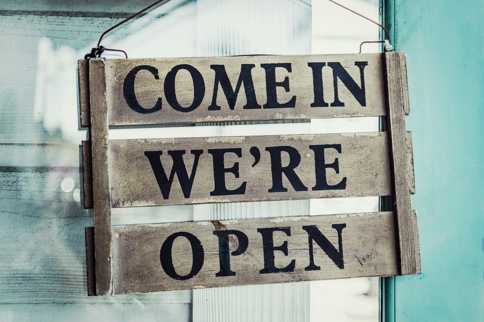 Small business owner with a business open sign